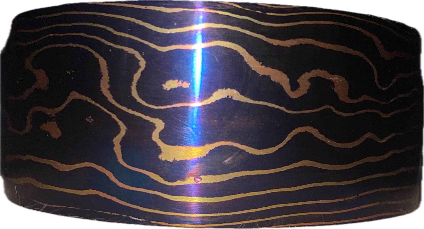 Close-up of dark layered steel with gold-toned contour lines