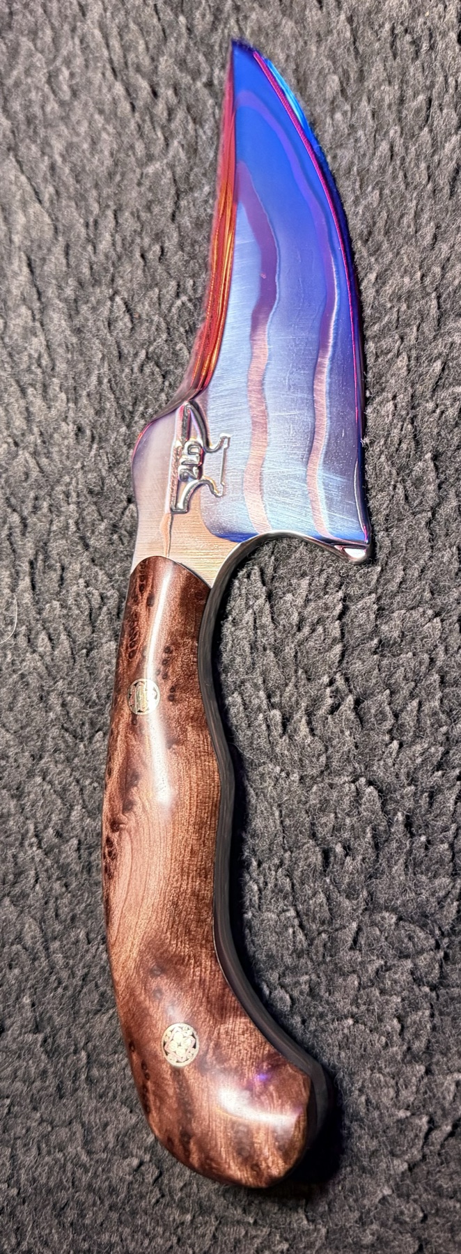 Full front profile of a Tulos knife with copper blade lines and a curved burl wood handle